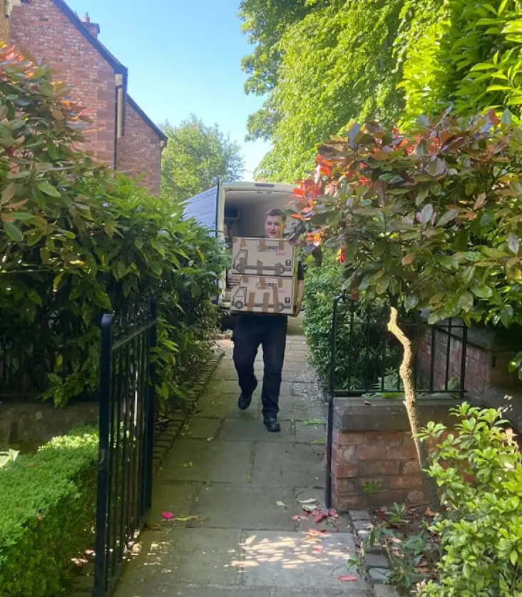 a single large item being carried down a garden path by a worker