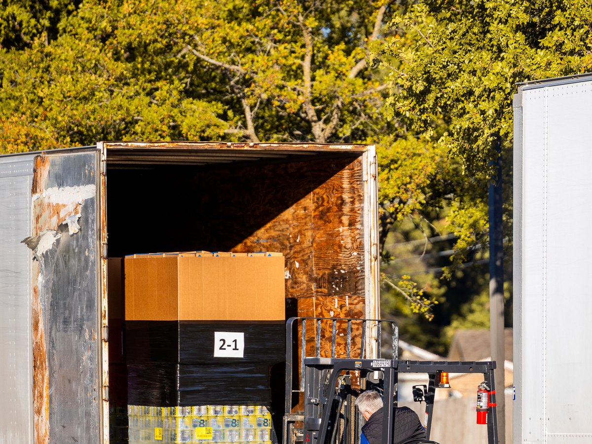 Forklift loading wrapped pallets into a commercial delivery truck